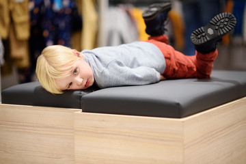 Tired little boy during shopping with parents