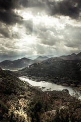 Dark moody mountains landscape in autumn season  around canyon with Rijeka Crnojevica river curve from high view in overcast day with dramatic sky in Europe country Montenegro  