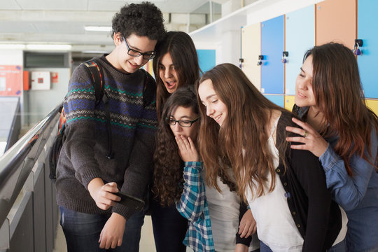 Group of student teenagers looking at a  phone photo