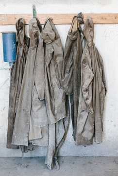 Used and Destroyed waterproof workwear hanging on hangers