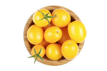 yellow tomatoes in a wooden plate isolated