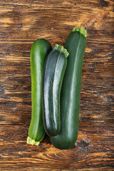 fresh zucchini on a natural brown wooden background.