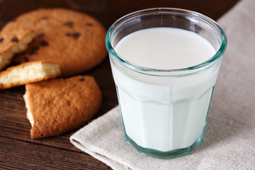 glass of milk with biscuits on wooden table