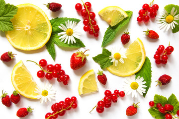 Fruits and berries lemon strawberry and red currant in a pattern with mint leaves on a white background with copy space top view flat