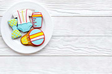 Cook gingerbread cookies on plate for baby shower on white wooden background top view mockup