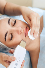 Face skin care. Young woman getting facial ultrasound cleaning