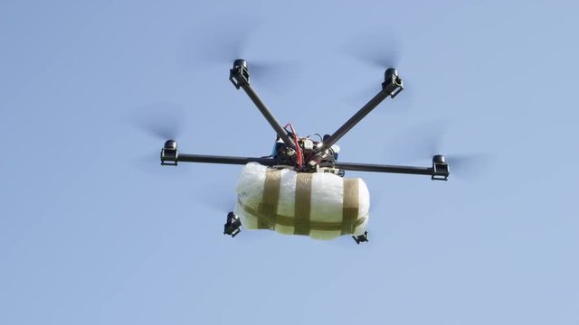CLOSE UP: Drone delivery of illegal drugs. UAV aircraft flying drug stash across the border. Air drone smuggling illegal drugs. Drug gangs and narco cartels using drone to drop off a cocaine package