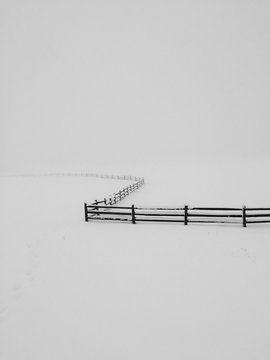 Lonely fense winding in winter snow