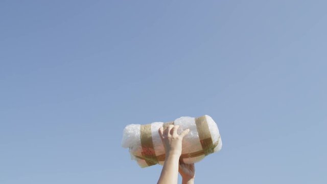 CLOSE UP: Unrecognizable person receiving big drug package by cargo drone delivery. Drone delivery of illegal drugs. UAV aircraft flying drug stash across the border. Air drone smuggling illegal drugs