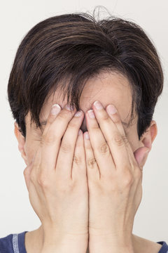 person hiding face behind her hands