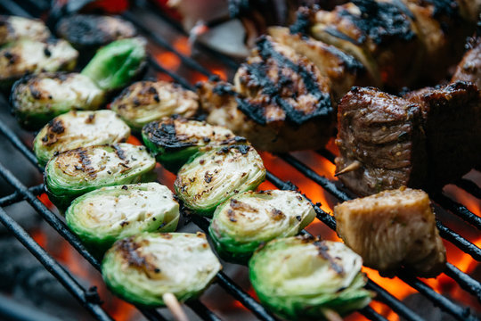 Skewered Brussels Sprouts and meat on a charcoal grill
