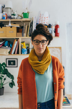 Portrait of Colorfully Dressed Young Female Artist in Naturally-Lit Studio