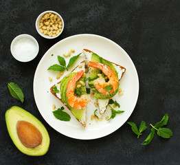 Sandwich with avocado, goat cheese, shrimp and arugula. View from above.