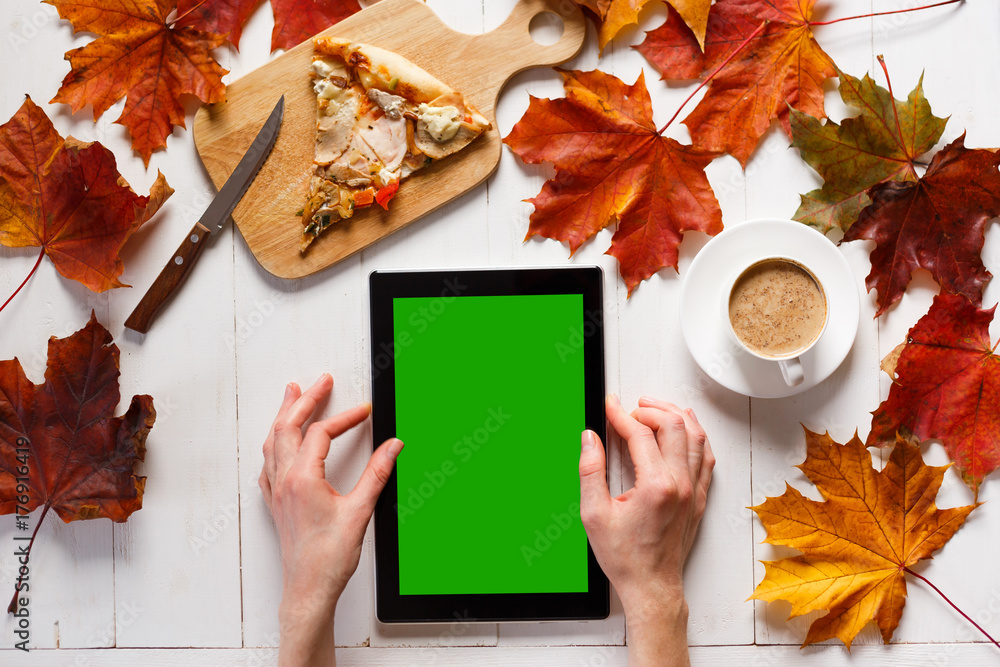 Wall mural womans hands with tablet with blank screen. female using tablet and drinking coffee with pizza