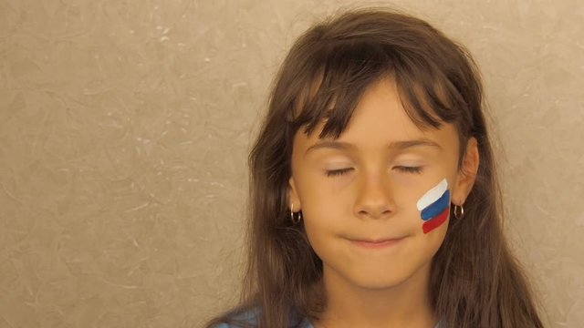 A girl with a flag of Russia painted on her face.