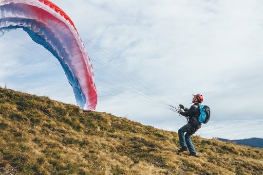 male paraglider raising his canopy to take off