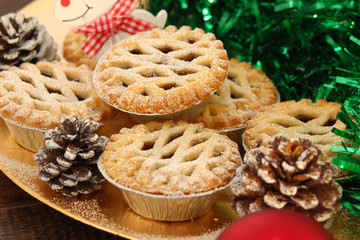 Christmas mince pies on a gold plate with red reindeer on a wood background   © maryrose5