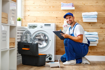 working man   plumber repairs  washing machine in   laundry