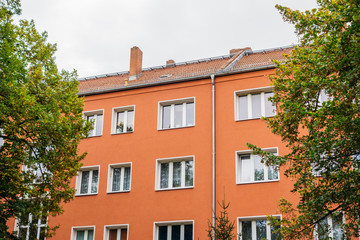 Fototapeta na wymiar red apartment house between trees