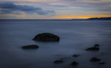 Morning long exposure with rocks,ocean,and a colorful sky Victoria British Columbia Canada