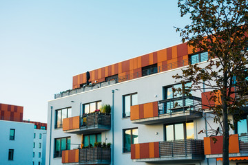 white facaded building with red modern roof