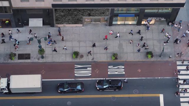 A high angle view of pedestrians and traffic on 5th Avenue in midtown Manhattan.  	