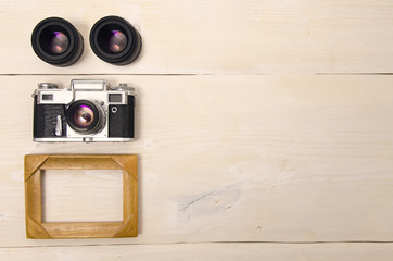 Top view, photography concept, lenses, camera and photo wooden frame. Copy space
