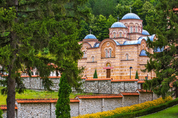 Orthodox church with a beautiful stone fence surrounded by fairy-tale nature, trees and mountain forest. Temple Trocrkva, Valjevo, Serbia.