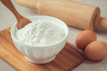Fototapeta na wymiar Flour in bowl with eggs and rolling pin