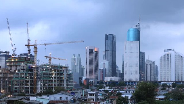 JAKARTA, Indonesia. October 12, 2017: Timelapse footage of crane and high rise buildings under construction with moving clouds at cloudy afternoon