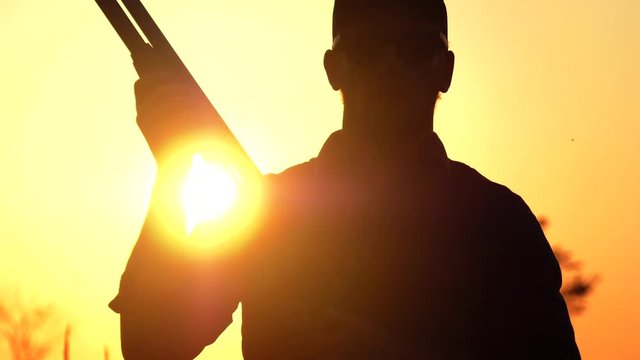 slow motion shot gun being pumped in the sunset 4k