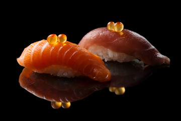 Closeup composition of fresh salmon sashimi sushi with caviar on a dark background