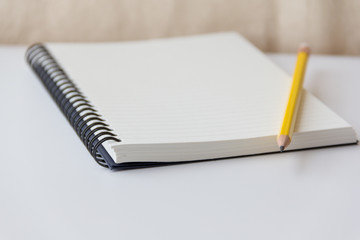 notebook paper and pencil closeup on white background