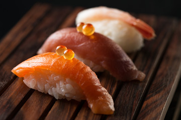 close up of sashimi sushi set on wooden plate