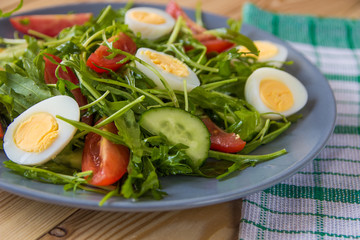 Fresh green salad with arugula, tomatoes, eggs and cucumber