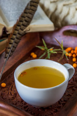 Vitaminic tea with sea-buckthorn on the wooden table