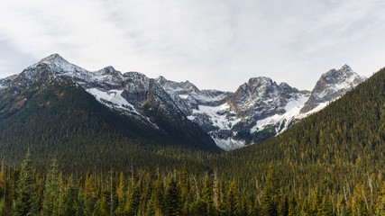 Early winter snow during Autumn season covering mountain peaks in the North Cascades National Park with Fisher Peak on the right.