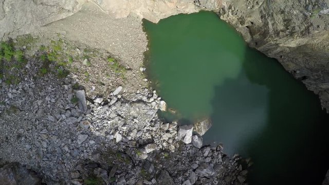 Tuimsky Proval 01. Deep technogenic collapse pit (failure) inside a mountain on the site of excavation of polymetallic ores. Static shot. Tuim, Shira district, Republic of Khakassia, Russia.