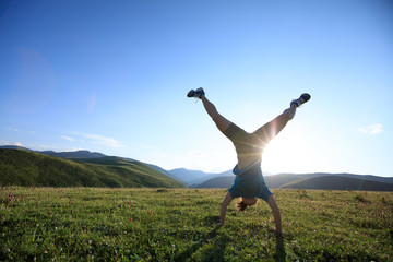 woman doing a handstand in a meadow