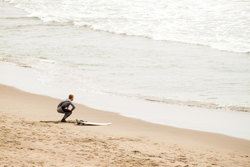 surfer stretching getting ready to go in water