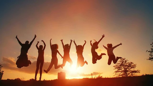 Cheerful People Jumping at Sunset