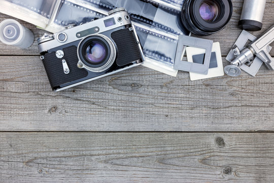 negative films, lenses and retro camera on wooden table background with copy space