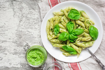 penne pasta with basil pesto and herbs in a plate with fork