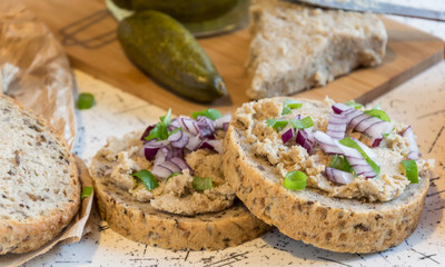 pork spread, lard and sour cucumbers on fresh round bread, sprinkled with spring and red onion