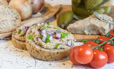 pork spread, lard and sour cucumbers on fresh round bread, sprinkled with spring and red onion