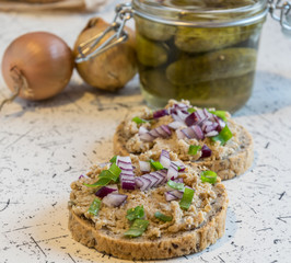 pork spread, lard and sour cucumbers on fresh round bread, sprinkled with spring and red onion