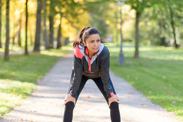 Smiling woman resting after jogging in park