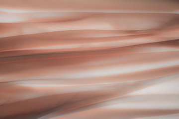 Detail of fabric in soft and light orange tones.