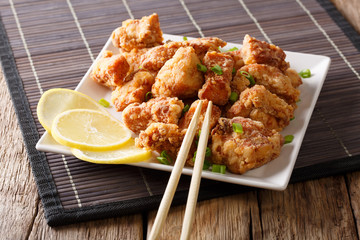 Japanese freshly prepared chicken karaage with lemon close-up on a plate. horizontal