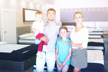 Happy family looking for new mattress in salon